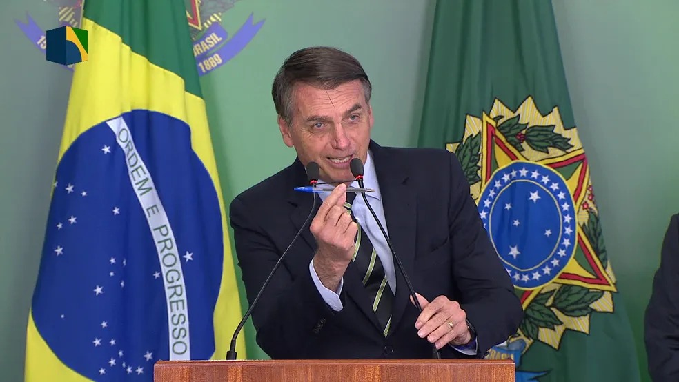 Bolsonaro exibe caneta durante cerimônia em Brasília em janeiro de 2019, quando assinou decreto para facilitar acesso às armas. — Foto: Reprodução/NBR