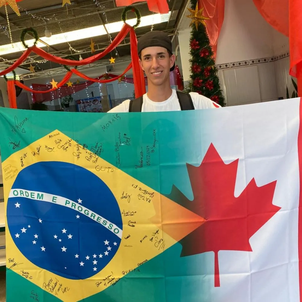 José Consani Neto segurando uma bandeira mesclada entre o Brasil e o Canadá. Foto: Divulgação